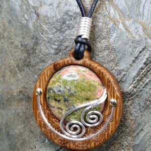 Cabochon of Unakite mounted in an Iroko textured wood bezel and decorated  with bright silver wire spirals.